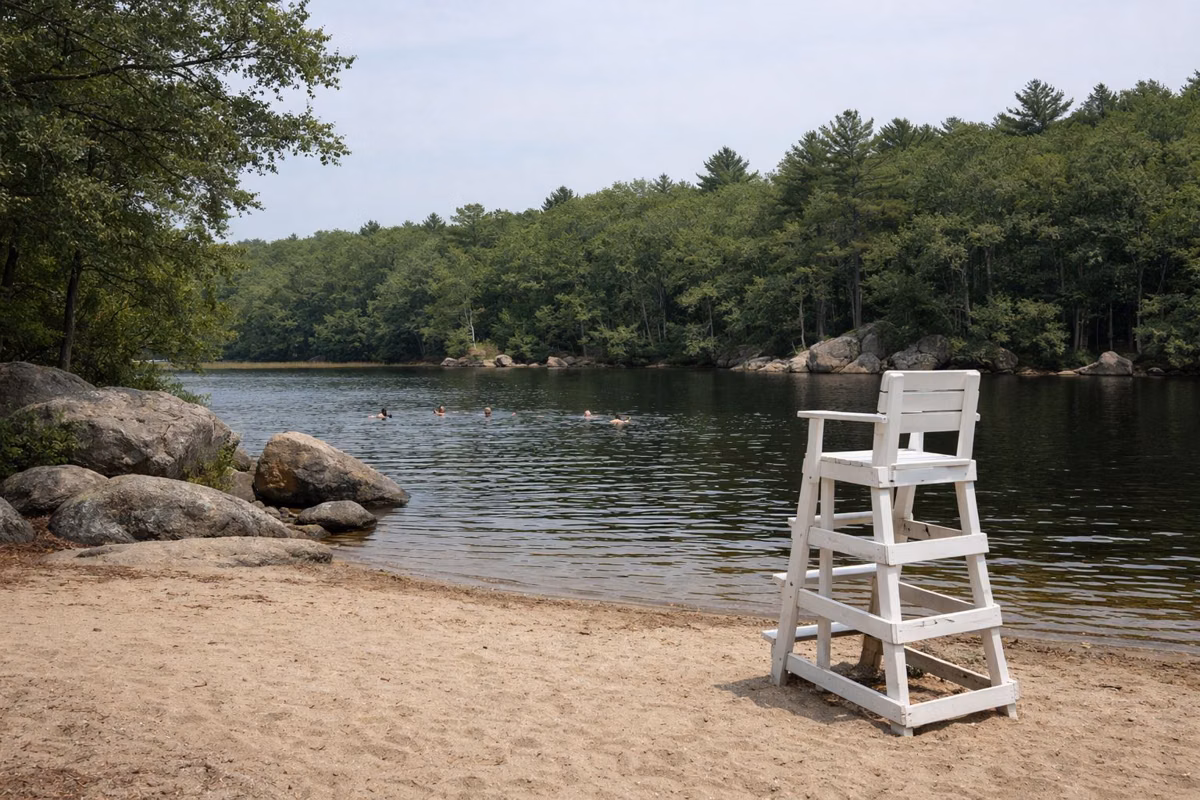 Sandy pond beach with a lifeguard chair in summer